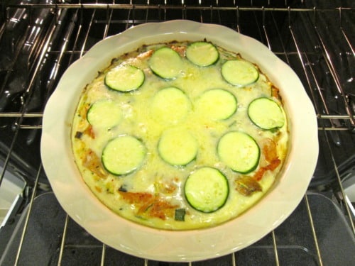 zucchini and kimchi quiche with a brown rice crust in an oven