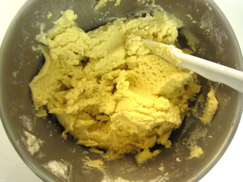 Citrus butter cookie dough mixed in a bowl with a white spatula, ready for shaping and baking.