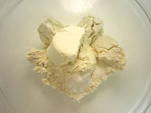 Dry ingredients including flour, baking soda, and salt in a mixing bowl for cookie dough.