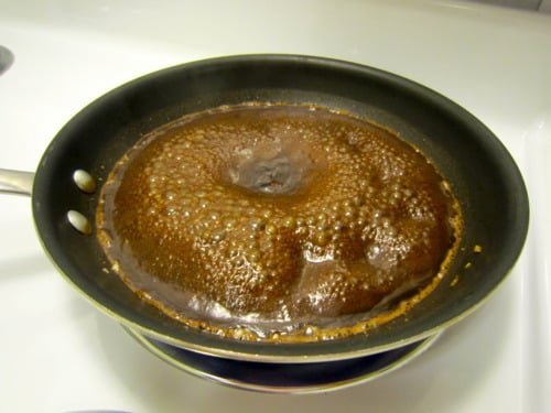 A bubbling balsamic glaze reducing in a skillet.