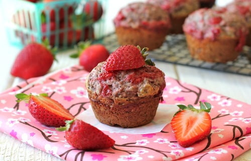 Strawberry Jam Poppyseed Muffins with sliced strawberries on a pink floral napkin.