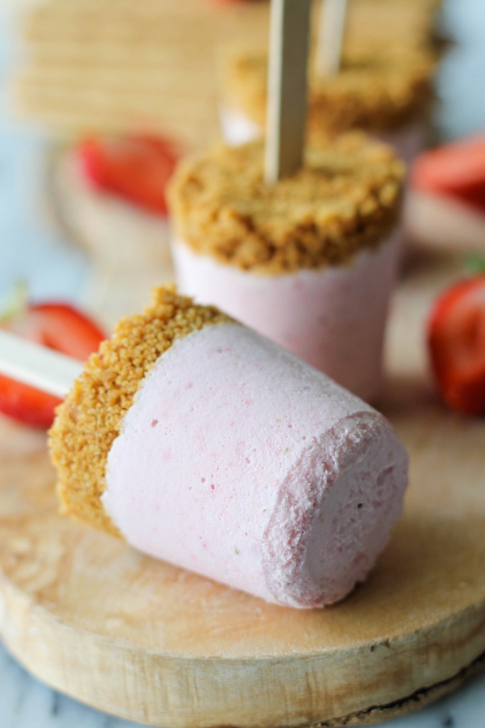 Strawberry Cheesecake Popsicles - Oh-so-creamy strawberry cheesecake in popsicle-form with a mile-high graham cracker crust!