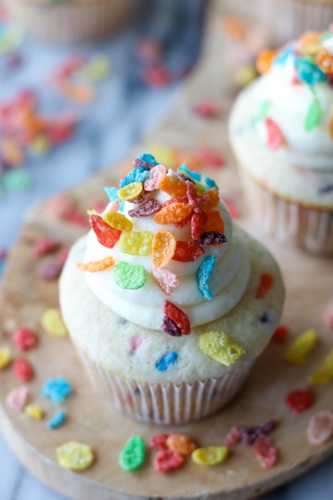 Fruity Pebble Cupcakes - Funfetti cupcakes topped with a vanilla buttercream frosting and sprinkled with colorful Fruity Pebbles!