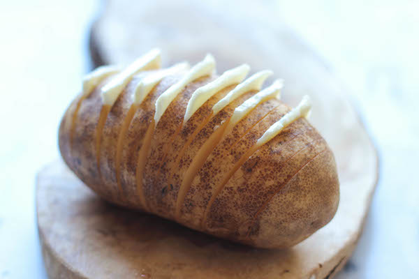 Loaded Hasselback Potatoes - A glorified baked potato loaded with melted cheddar cheese, sour cream, and crisp bacon bits!