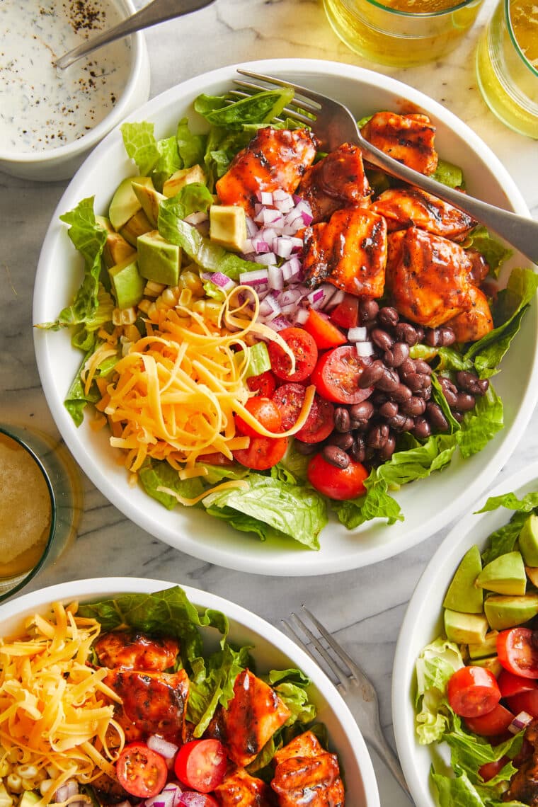 BBQ Chicken Salad - Smoky BBQ chicken, corn, tomatoes, black beans, avocado + cheese drizzled with homemade Ranch. An instant family favorite!