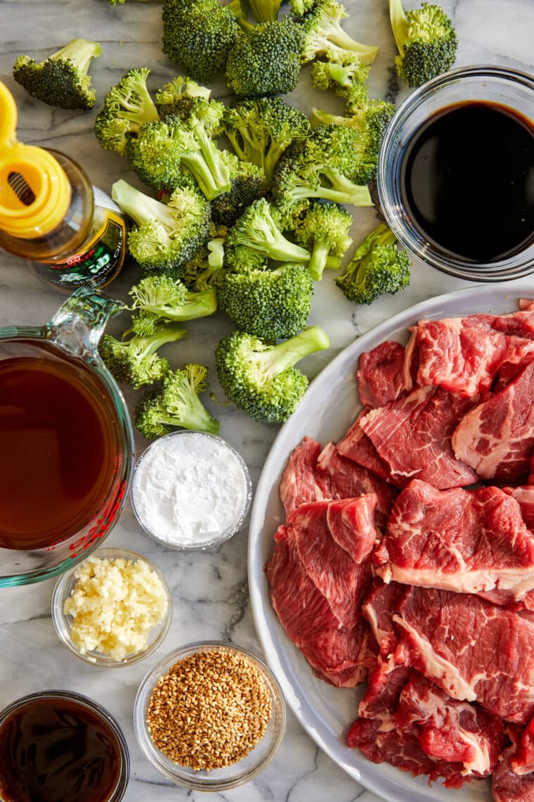 close-up of a comforting bowl of slow cooker beef and broccoli. Sliced beef is coated in a thick, glossy brown sauce and mixed with tender, vibrant green broccoli florets.