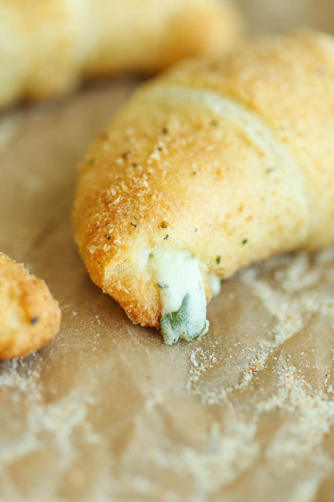 Spinach and Artichoke Dip Roll Ups - Everyone's favorite dip is stuffed into a flaky, buttery crescent roll, oozing with all that melted cheesy goodness!