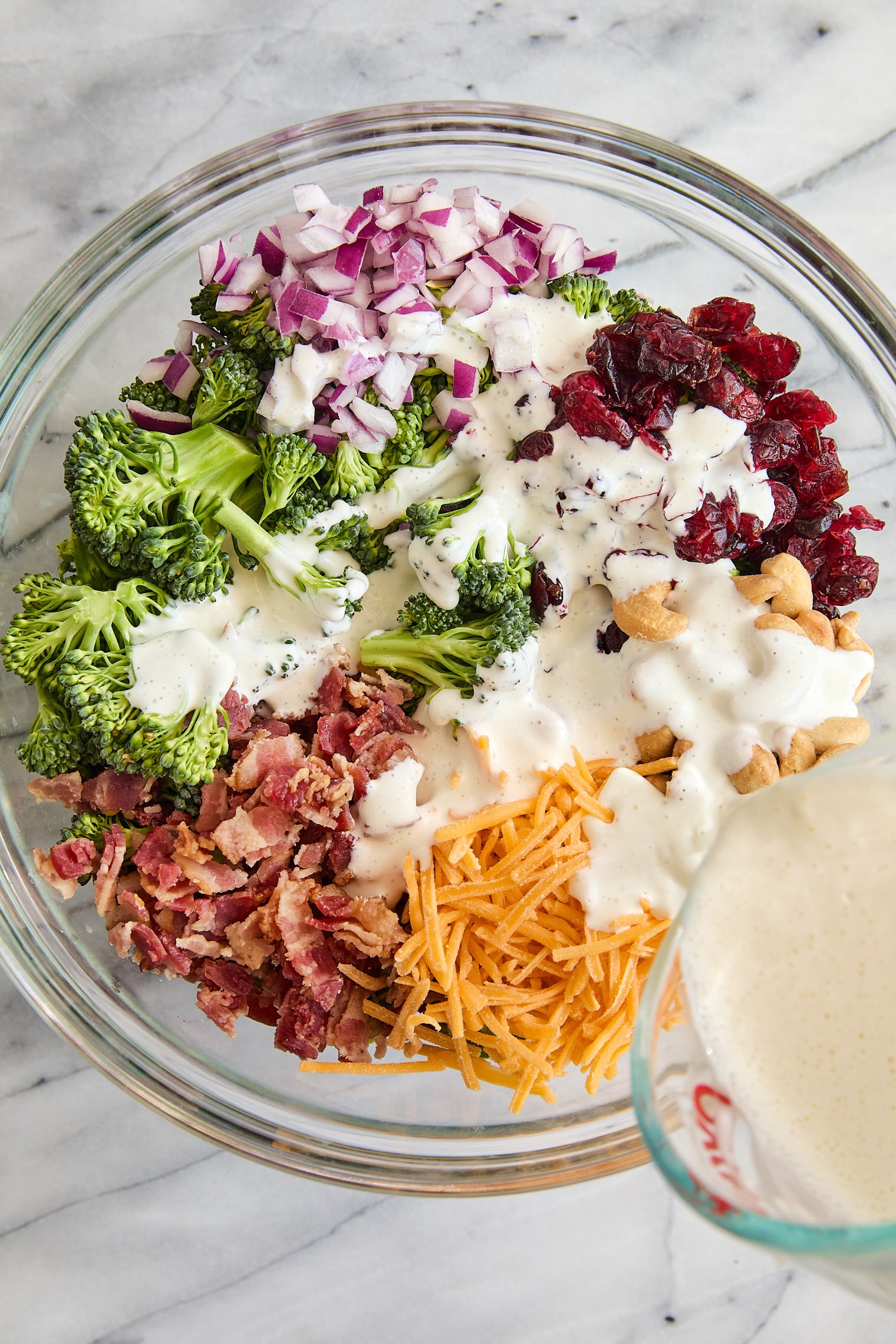 Creamy Broccoli Salad - Seriously the BEST broccoli salad ever! With cheese, cashews, red onion, crispy bacon + the creamiest dressing ever!