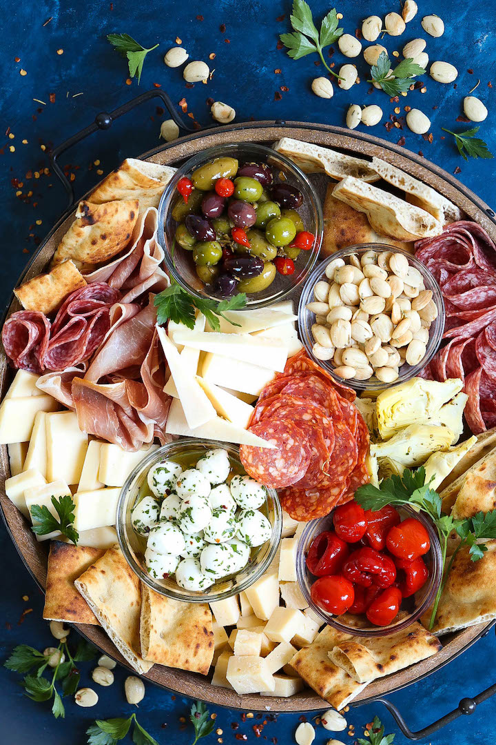 Antipasto Appetizer Cheese Board - Learn how to build the absolute PERFECT antipasto platter! It's unbelievably easy and sure to be a crowd-pleaser for all your guests! Served with cured meats, fresh cheeses, artichoke hearts, olives, nuts, peppers and focaccia!