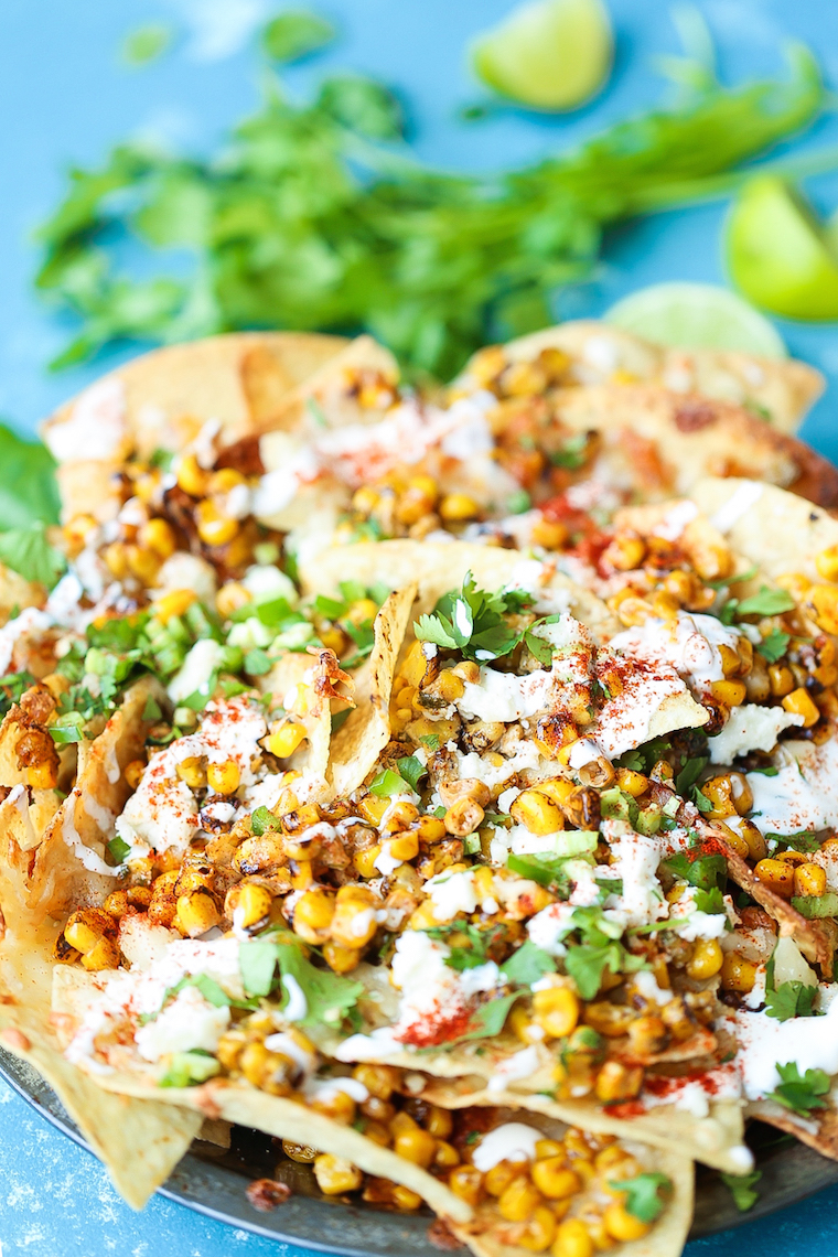 Mexican Street Corn Nachos - Everyone's favorite Mexican elote is made into the BEST nachos! Loaded with roasted corn, lime, chili powder and Mexican crema!