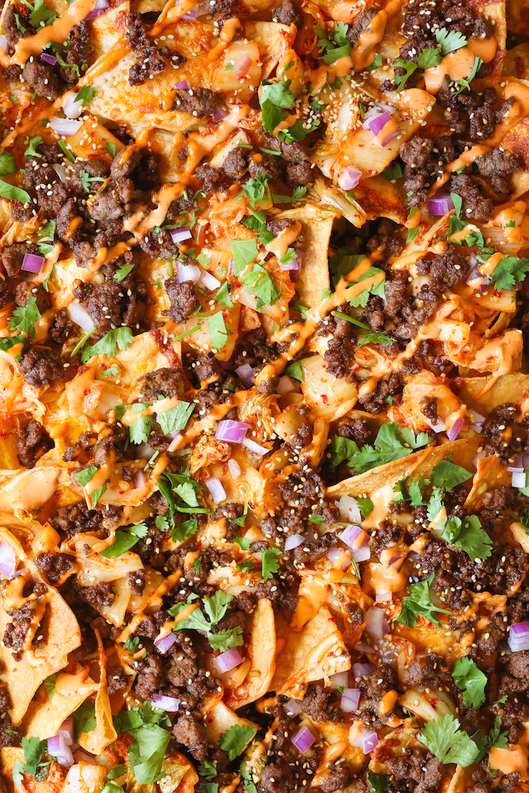 Korean Beef Nachos - These will be the BEST NACHOS of your life! Topped with everyone's favorite Korean beef, caramelized kimchi + a Sriracha mayo drizzle!