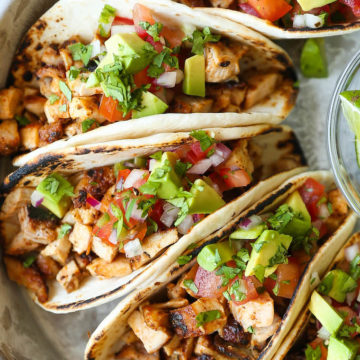Chicken tacos recipe plated with cilantro and lime wedges