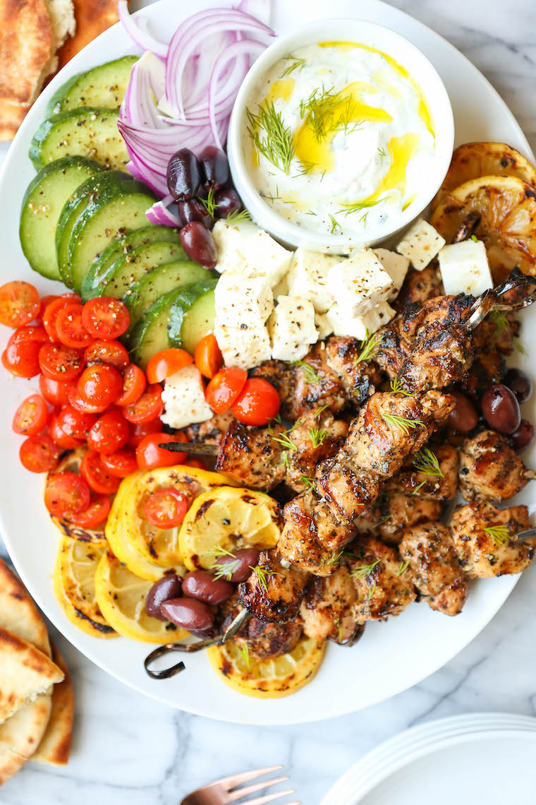 Greek chicken kabobs on platter with tzatziki sauce