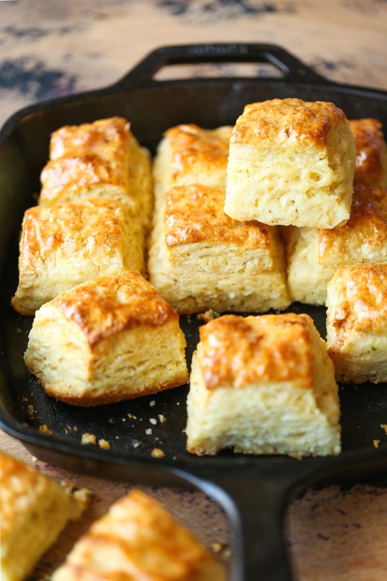 Golden brown buttermilk biscuits with flaky layers served in a cast iron skillet.