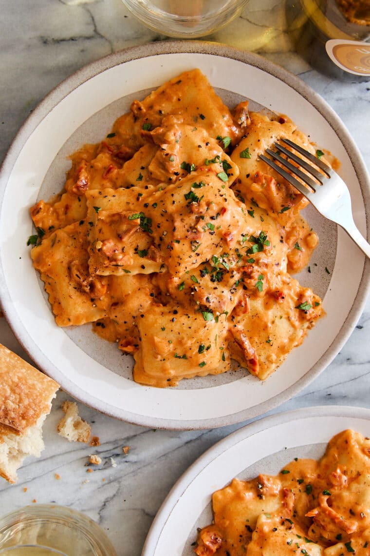 Pillow-y ravioli with the dreamiest, most velvety sun dried tomato cream sauce! A 30-minute weeknight dinner yet fancy enough for company!