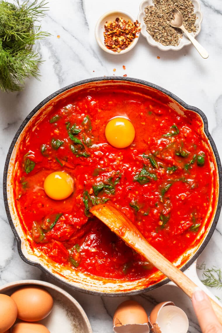 Eggs in Purgatory - An easy, rustic, one pan dish with eggs poached in a rich, savory, garlicky tomato sauce. Best served with all the crusty bread for dunking!